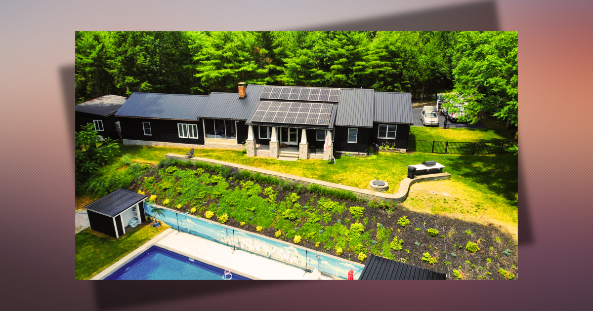 A large home with a solar array and landscaped grounds