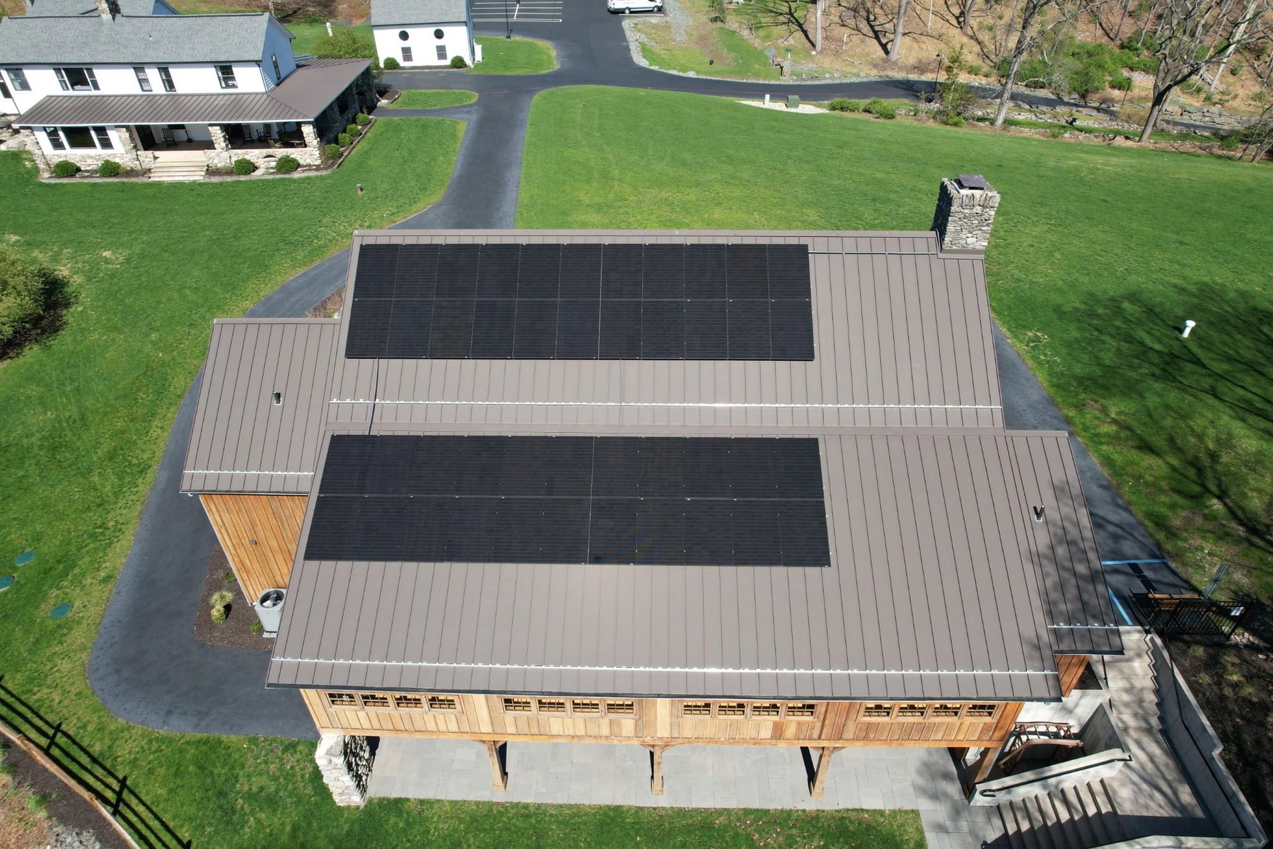 Aerial view of a barn-style building with two Solar Bear rooftop arrays