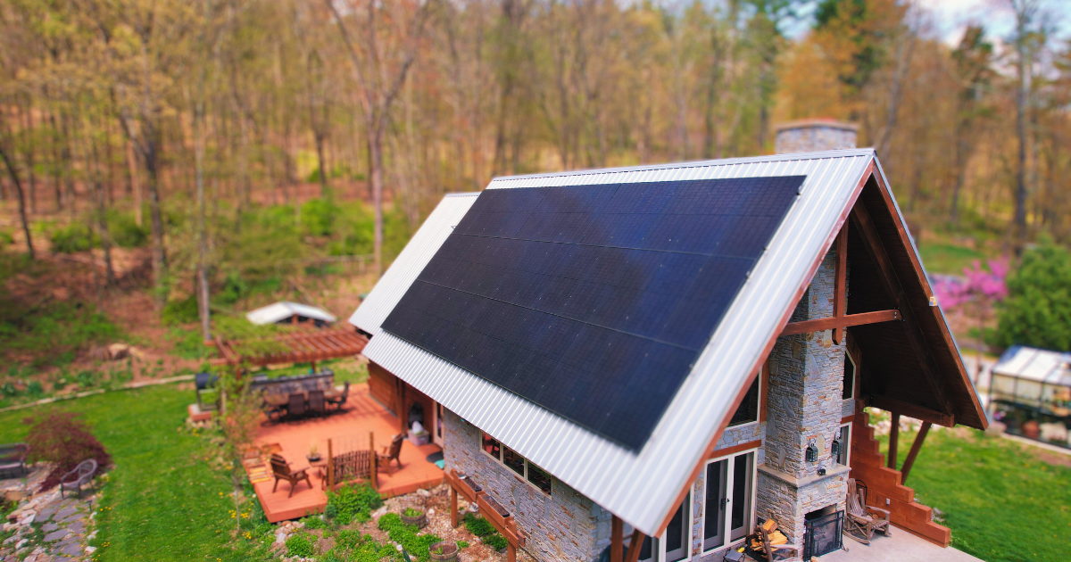 An off-grid cabin with a metal-roof solar array in the woods